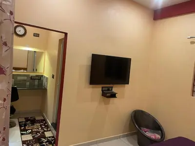 a room with a flat screen tv on the wall at Four Seasons Homestay single room in Madikeri
