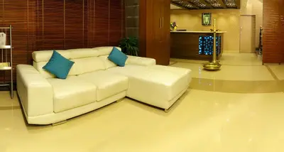 a white couch with blue pillows in a living room at Vishnu Inn in Guruvāyūr
