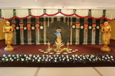 a woman taking a picture of a altar with flowers at Vishnu Inn in Guruvāyūr