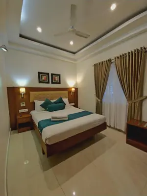 a bedroom with a large bed and a window at Vishnu Inn in Guruvāyūr