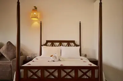 a bed with a stuffed animal sitting on top of it at Welbeck Vintage By Oxygen Resorts in Ooty