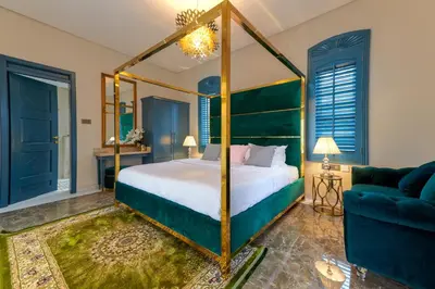 a bedroom with a four poster bed and a couch at Clouds Nest By Aanvis Inn in Ooty