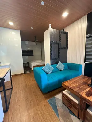 a living room with a blue couch and a table at WHOOSH HOMES in Cochin