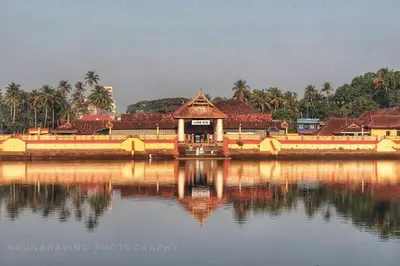 a building in the middle of a body of water at Furnished 2 BHK Family Apartments near Triprayar Shree Rama Temple - Beevees Homes Thriprayar in Thanniyam