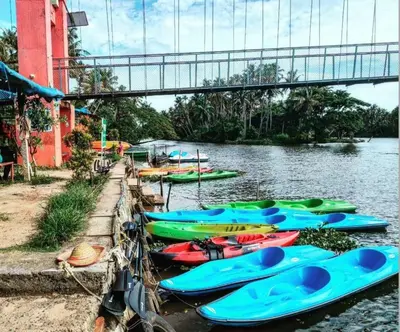 a group of kayaks are lined up on the water at Furnished 2 BHK Family Apartments near Triprayar Shree Rama Temple - Beevees Homes Thriprayar in Thanniyam