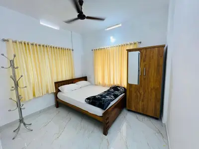 a small bedroom with a bed and a mirror at Furnished 2 BHK Family Apartments near Triprayar Shree Rama Temple - Beevees Homes Thriprayar in Thanniyam