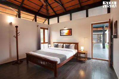 a bedroom with a large bed in a room at StayVista at Ava - The Country House with Breakfast & Miniature Golf in Mysore