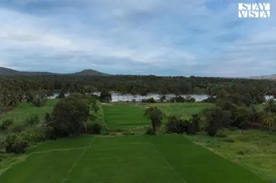 an aerial view of a field with a river and trees at StayVista at Ava - The Country House with Breakfast & Miniature Golf in Mysore