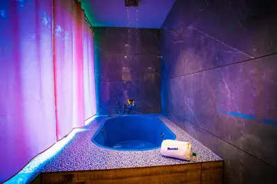 a bathroom with a blue tub in a purple room at Bluemist Resorts in Athirappilly