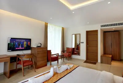 a hotel room with a bed and a dining room at Bluemist Resorts in Athirappilly