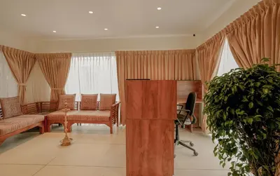 a living room with a couch and a chair at Bluemist Resorts in Athirappilly
