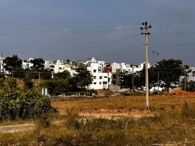 a telephone pole in a field with buildings in the background at DEEYA Home Stay - A Luxury Family Guest House in Mysore