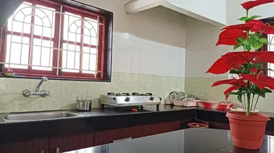 a kitchen with a sink and red flowers in a pot at SHI's Alaya 3BHk Villa in Coimbatore, near Railway station in Pīlamedu