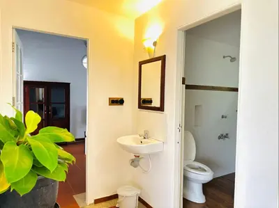 a bathroom with a sink and a toilet at THALIMALA BUNGALOW in Vythiri