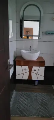 a bathroom with a sink and a mirror at Yogis Inn in Kozhikode