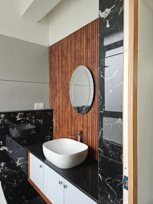 a bathroom with a white sink and a mirror at Yogis Inn in Kozhikode