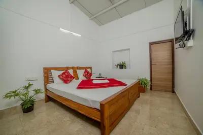 a bedroom with a bed with a red blanket on it at Shola Gardens , Kotagiri in Kotagiri