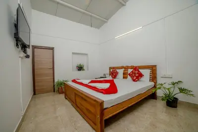 a bedroom with a bed and a television in it at Shola Gardens , Kotagiri in Kotagiri