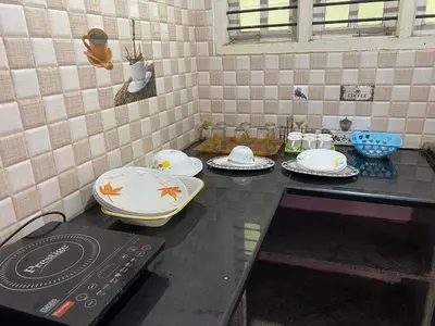 a kitchen counter with plates and dishes on it at Lovely Private Queen Bed Room in Shared 2 BHK Apartment in Mysore
