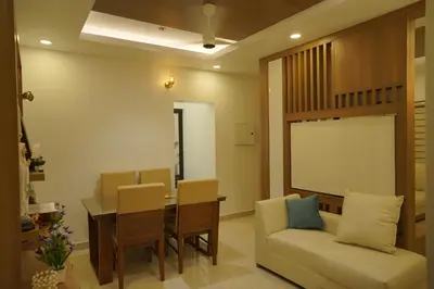 a living room with a table and chairs and a couch at Luxury Homes - Cochin Airport - Nedumbassery in Angamali
