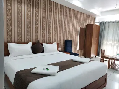 a bedroom with a large bed with two pillows on it at Wayanad Palace in Ambalavayal