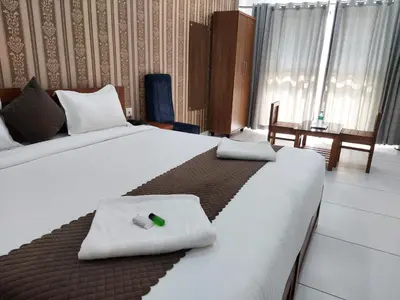 a hotel room with two beds with towels on them at Wayanad Palace in Ambalavayal