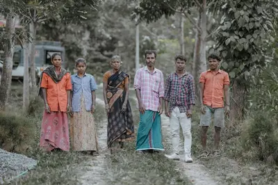 a group of people standing on a dirt road at Qatsyir Horizon in Varagampadi