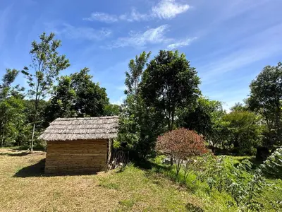 a small wooden building in a field with trees at Qatsyir Horizon in Varagampadi