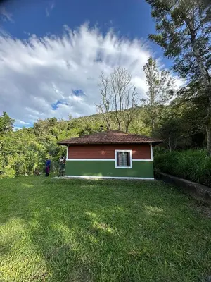 a small red and green house in a yard at Qatsyir Horizon in Varagampadi