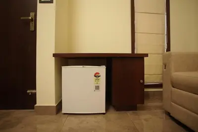 a small white refrigerator sitting next to a table at Pabis luxurious stay in Vythiri