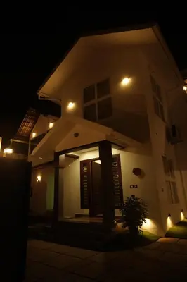 a house lit up at night with lights at Pabis luxurious stay in Vythiri