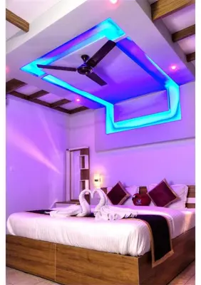 a room with a bed with purple lights on it at Sriniketana Homestay in Madikeri