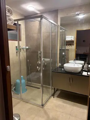 a bathroom with a glass shower and a sink at SylVan Resort in Wayanad