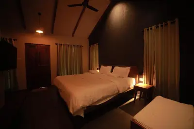 a bedroom with a large bed in a dark room at SylVan Resort in Wayanad