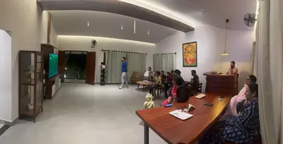 a group of people sitting at tables in a room at SylVan Resort in Wayanad