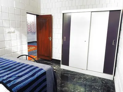 a room with a bed and a glass door at Mannat Inn TS Mysore - Family Homestay in Mysore