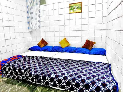a bedroom with a blue bed with pillows on it at Mannat Inn TS Mysore - Family Homestay in Mysore