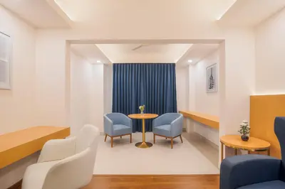 a waiting room with a table and chairs at Hotel Turmeric in Erode