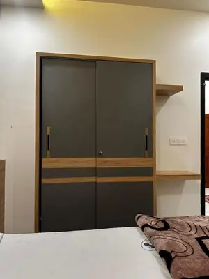 a bedroom with a large closet with black doors at MEDURE International in Kottakkal