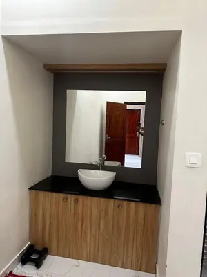 a bathroom with a sink and a mirror at MEDURE International in Kottakkal