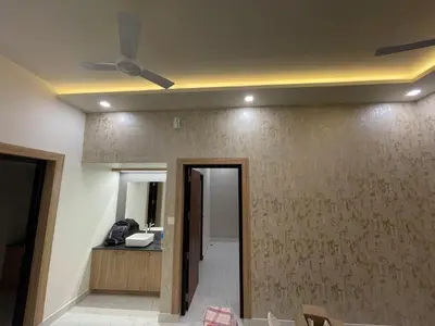 a living room with a ceiling fan and a hallway at MEDURE International in Kottakkal