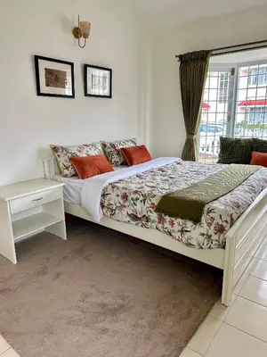 a bedroom with a large bed and a window at Hoopoe House, Ooty in Ooty