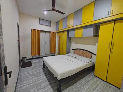 a bedroom with yellow cabinets and a bed in it at 2Bhk holiday home in Mysore
