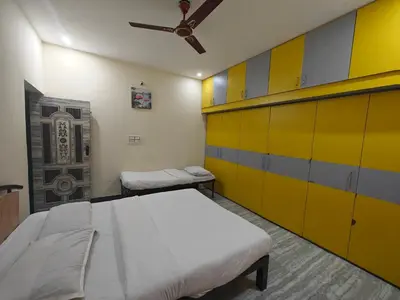 a hospital room with two beds and yellow cabinets at 2Bhk holiday home in Mysore