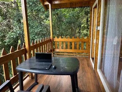 a laptop computer sitting on a table on a porch at Coorg Jungle Mist in Madikeri