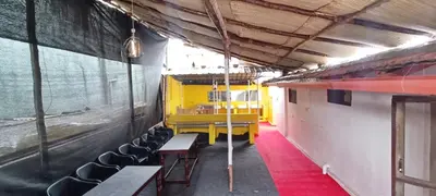 a room with a yellow table and chairs in a train at xplorest in Mysore