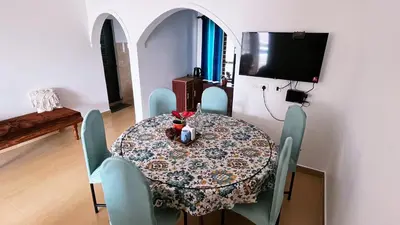 a dining room with a table and chairs and a television at Moon Wings Mountain Resort in Kanthalloor