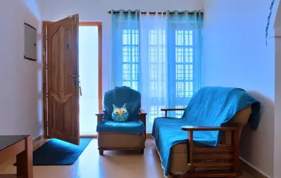 a room with a blue chair with a blue blanket at Moon Wings Mountain Resort in Kanthalloor