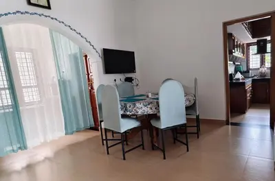 a dining room table with chairs and a television at Moon Wings Mountain Resort in Kanthalloor
