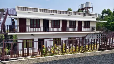 a man standing on the balcony of a building at Moon Wings Mountain Resort in Kanthalloor